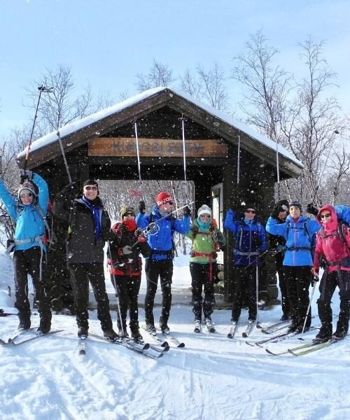 © François Trifard Groupe de skieurs de fond devant un refuge sous la neige - Kungsleden - Suède