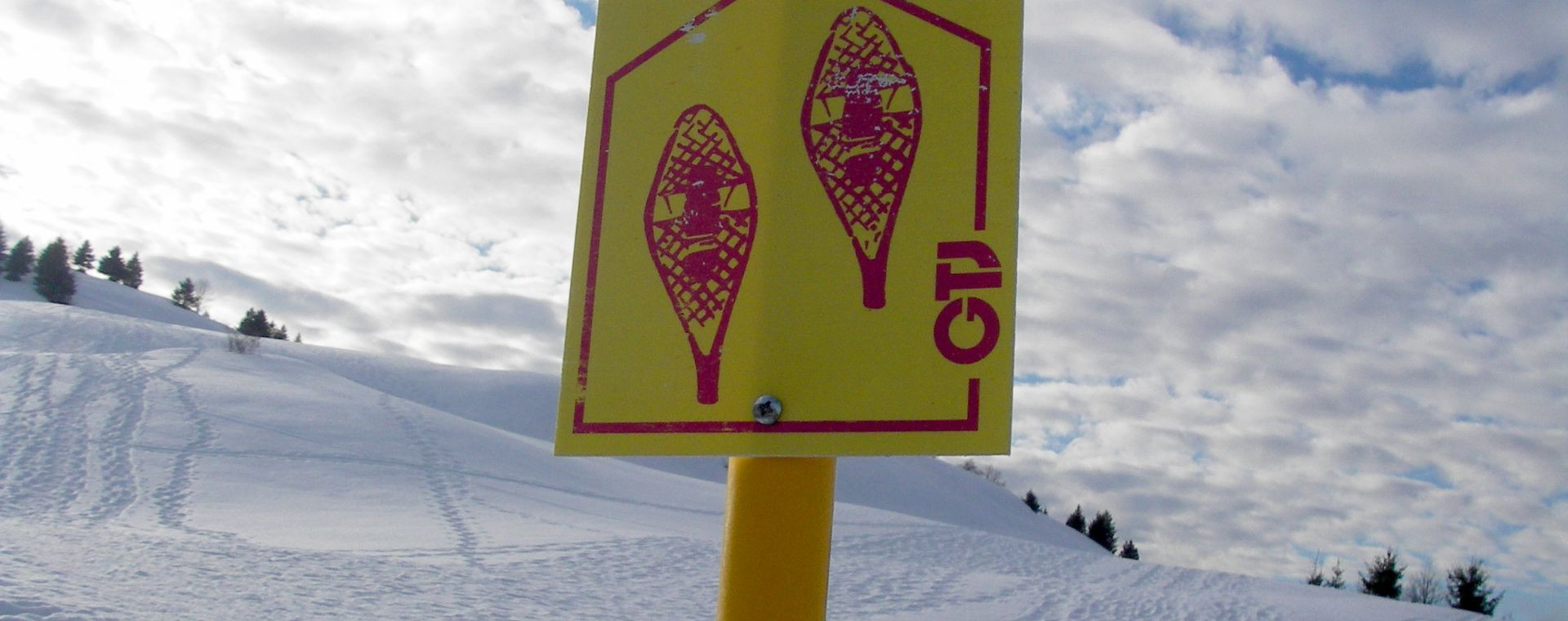 Balise de sentier raquettes dans la neige - Jura en hiver, France